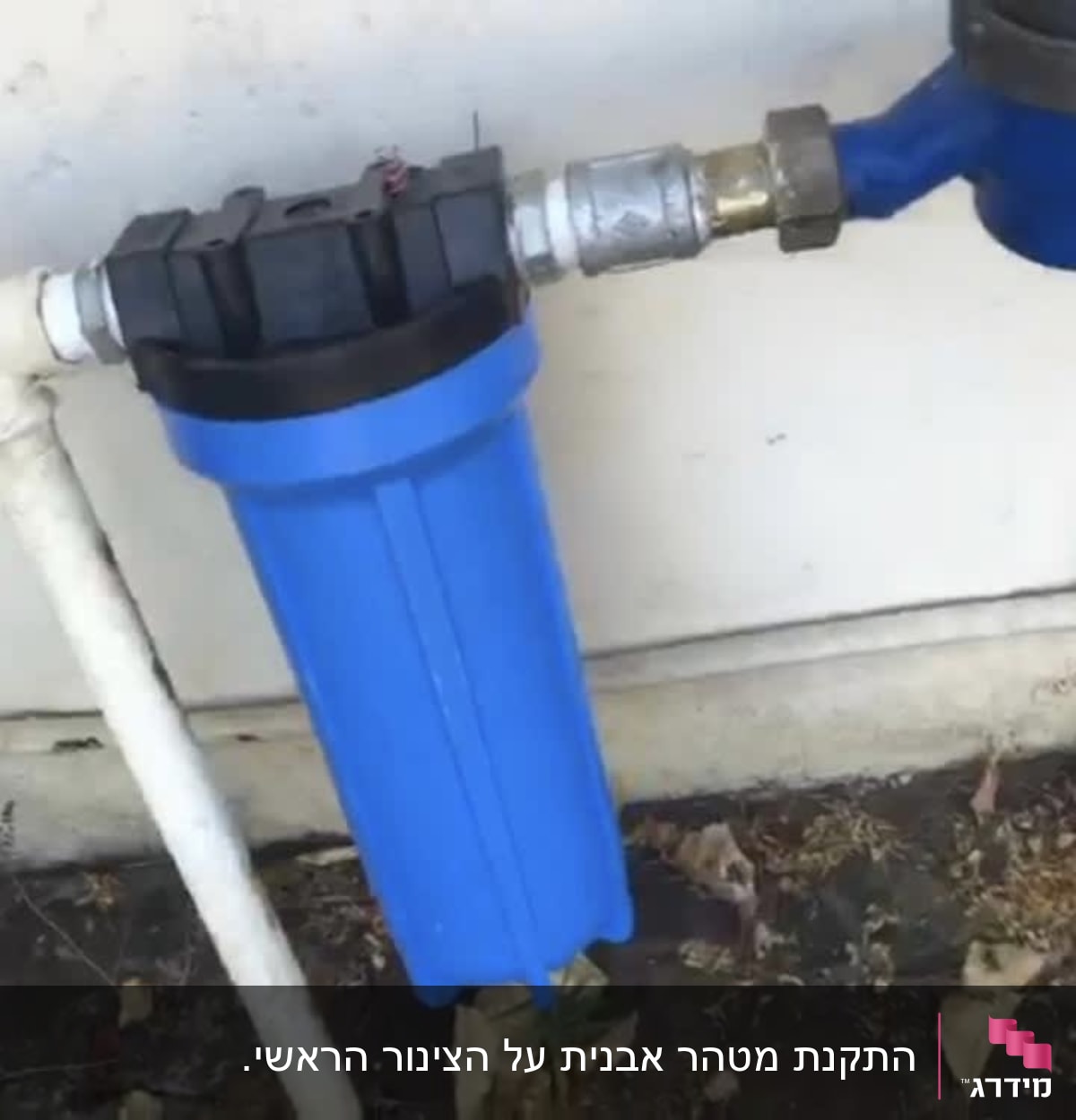 מסנן מים כחול מחובר לצינור לבן